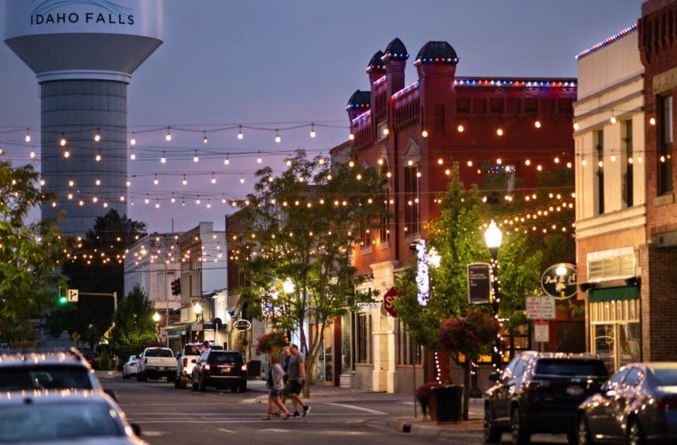 Downtown Idaho Falls at dusk, lit with string lights.